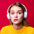 Beautiful woman with joystick and headphones on red background